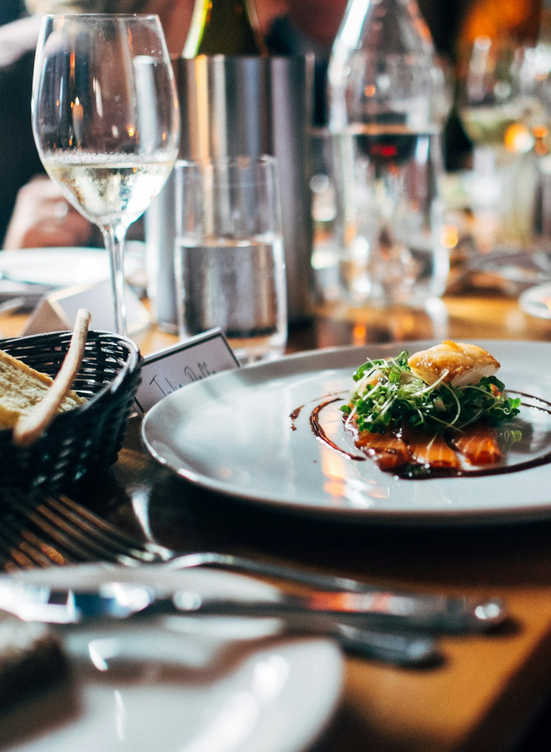 The first course set down at a candlelit table
